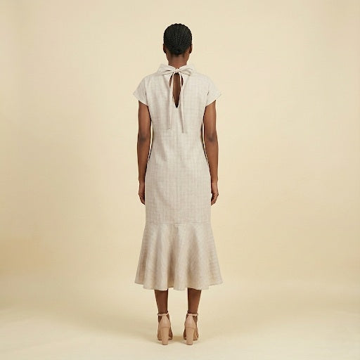 High-neck dress with tie closure.